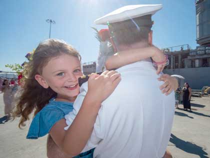 SAN DIEGO (Aug. 28, 2023) Lt. Cmdr. Kevin McDermott embraces his family from the pier of the Arleigh Burke-class guided-missile destroyer USS Paul Hamilton (DDG 60) in San Diego, Aug. 28, 2023. Paul Hamilton returned to homeport following a seven-month deployment in U.S. 5th Fleet area of operations. U.S. Navy photo by MC2 Elliot Schaudt