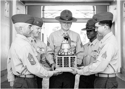 U.S. Marines with Marine Corps Recruit Depot San Diego rifle-team pose for a photograph with the San Diego Trophy Western Division at Marine Corps Recruit Depot San Diego, California, Feb. 26, 2025. The Marine Corps Marksmanship Competition West was held in conjunction with several other competitions around the Marine Corps to find the top shooters who will go on to compete in the Marine Corps Marksmanship Championships in Quantico, Virginia for a chance to join the Marine Corps Shooting Team. U.S. Marine Corps photo illustration by Lance Cpl. Eric Valerio