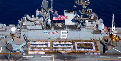 CORAL SEA (Aug. 2, 2025) Sailors assigned to the amphibious assault ship USS America (LHA 6) and U.S. Marines with the 31st Marine Expeditionary Unit (MEU) stand in formation for a photo commemorating 250 years of naval service, while conducting operations in the Coral Sea, in August. USS America returned to Naval Base San Diego, Sept. 25, marking the end of its six-year forward deployment to Sasebo, Japan and the U.S. 7th Fleet area of operations. U.S. Navy photo by MC3 Kenneth Melseth.